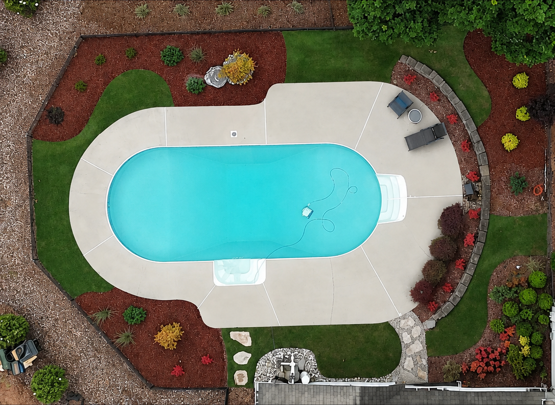 Poolside landscaping with turf, mulch beds, and plantings